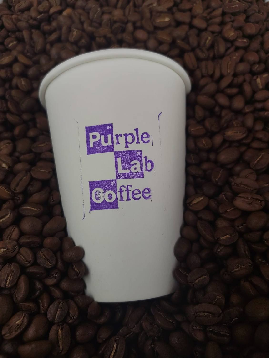 Purple Lab Coffee Becher auf frisch gerösteten Bohnen