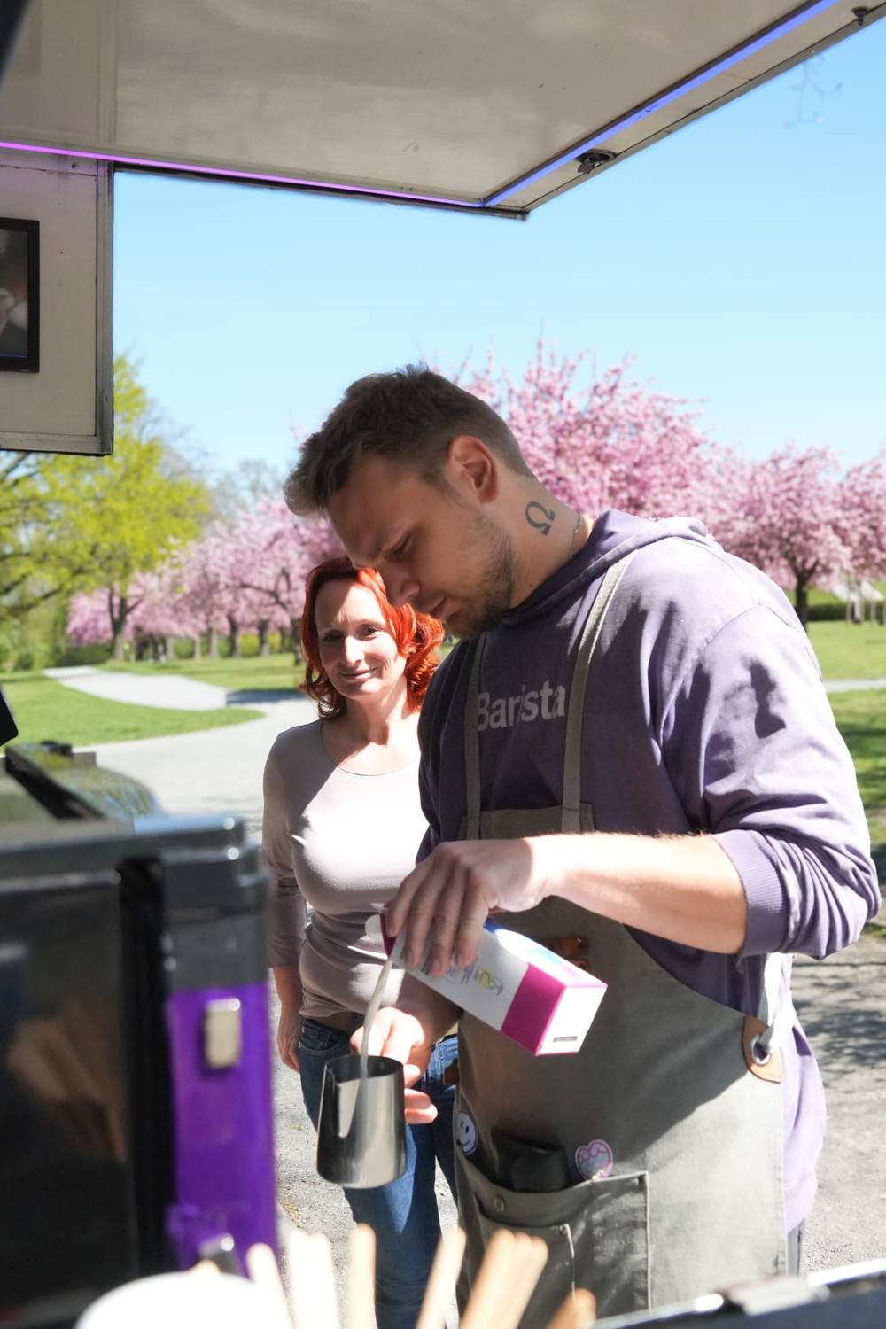 Barista bereitet Specialty Coffee zu, Kirschblüten im Hintergrund